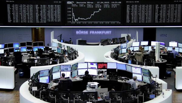 Traders are pictured at their desks in front of the DAX board at the Frankfurt stock exchange April 27, 2015 - Sputnik International