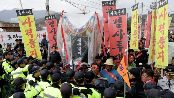 Residents stand in front of police officers who blocked their march toward the U.S. Army's Rodriguez range during a rally to oppose the live firing drills of the U.S. Forces, in Pocheon, South Korea, Friday, April 3, 2015 - Sputnik International