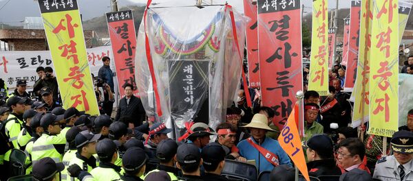 Residents stand in front of police officers who blocked their march toward the U.S. Army's Rodriguez range during a rally to oppose the live firing drills of the U.S. Forces, in Pocheon, South Korea, Friday, April 3, 2015 - Sputnik International