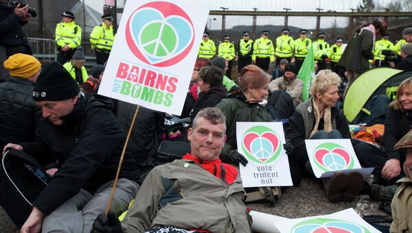 Protesters calling for an end to the Trident nuclear programme holds placards at a blockade in the road in front of HM Naval Base Clyde in Faslane, Scotland, northeast of Glasgow, on April 13, 2015 the UK base for Trident - Sputnik International