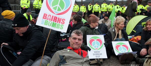 Protesters calling for an end to the Trident nuclear programme holds placards at a blockade in the road in front of HM Naval Base Clyde in Faslane, Scotland, northeast of Glasgow, on April 13, 2015 the UK base for Trident - Sputnik International
