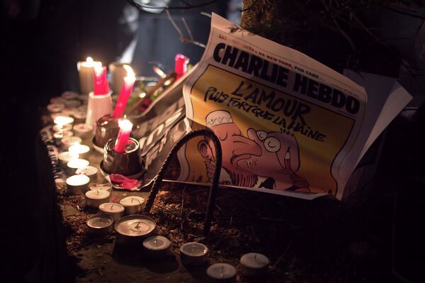 A copy of the Charlie Hebdo issue printed after the massacre at their Paris offices is placed at an impromptu memorial in Brussels during a solidarity gathering. The text reads Love is stronger than hate. - Sputnik International