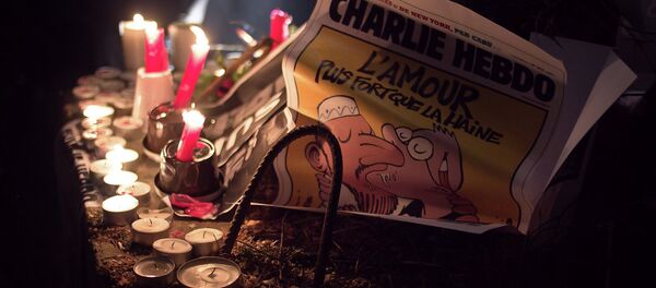 A copy of the Charlie Hebdo issue printed after the massacre at their Paris offices is placed at an impromptu memorial in Brussels during a solidarity gathering. The text reads Love is stronger than hate. A copy of the Charlie Hebdo issue printed after the massacre at their Paris offices is placed at an impromptu memorial in Brussels during a solidarity gathering. The text reads Love is stronger than hate. - Sputnik International