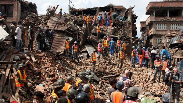 People watch as rescuers search for bodies at the site of a building which collapsed during an earthquake in Bhaktapur near of Kathmandu, Nepal in this Red Cross handout picture taken on April 29, 2015 - Sputnik International