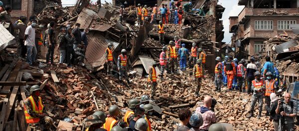 People watch as rescuers search for bodies at the site of a building which collapsed during an earthquake in Bhaktapur near of Kathmandu, Nepal in this Red Cross handout picture taken on April 29, 2015 People watch as rescuers search for bodies at the site of a building which collapsed during an earthquake in Bhaktapur near of Kathmandu, Nepal in this Red Cross handout picture taken on April 29, 2015 - Sputnik International