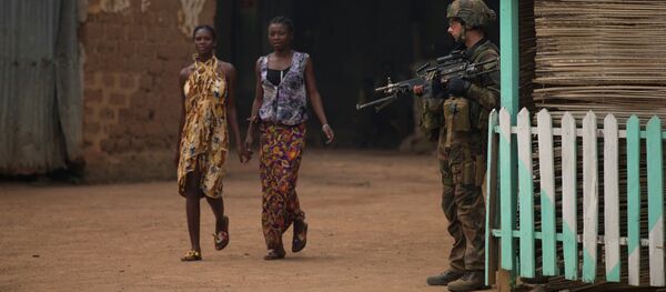 Girls hold hands as they walk past a French soldier holding a position, during an operation to secure part of the Miskine neighborhood, in Bangui, Central African Republic, Thursday, Dec. 26, 2013 - Sputnik International