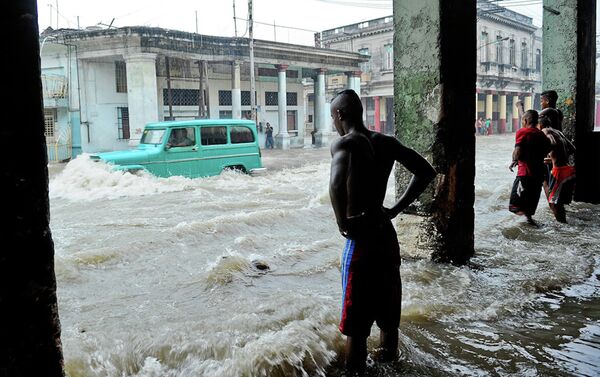 A car wades through a flooded street. - Sputnik International