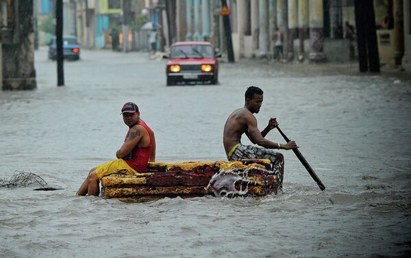 Two men on a makeshift raft sail through a flooded street. - Sputnik International