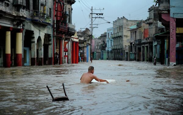 A man wades through a flooded street. - Sputnik International
