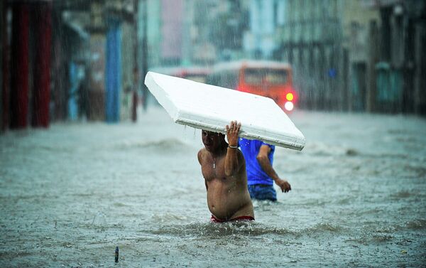 People wade through a flooded street. - Sputnik International