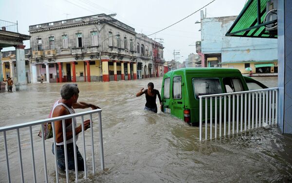 People wade through a flooded street during an intense rainstorm in Havana. - Sputnik International