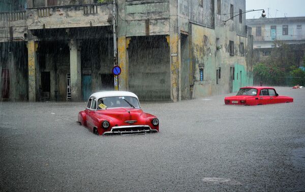 Stranded cars remain in a flooded street during an intense rainstorm in Havana. - Sputnik International