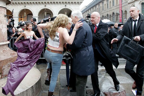 Femen activists with Le Pen Top Fascist painted on their bodies appear as France’s far-right National Front president Marine Le Pen places a wreath at Joan of Arc statue during its annual May Day march, in Paris, France, Friday, May 1, 2015 Femen activists with Le Pen Top Fascist painted on their bodies appear as France’s far-right National Front president Marine Le Pen places a wreath at Joan of Arc statue during its annual May Day march, in Paris, France, Friday, May 1, 2015 - Sputnik International