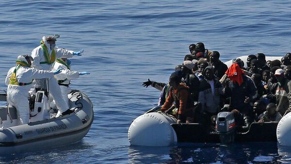 Italian Financial Police rescue unit approaches an inflatable dinghy crowded with migrants off the Libyan coast, in the Mediterranean Sea, Wednesday, April 22, 2015 - Sputnik International
