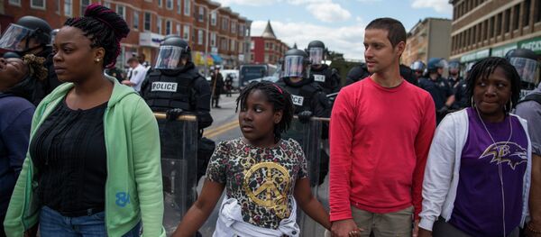 From left, Adrienne Horton, 11 year-old Shenya Milford, Vinny Bevivino, and Lakia McDaniel, all from Baltimore, Md., gather to sing Amazing Grace during a gathering of demonstrators after an evening of riots following the funeral of Freddie Gray on Tuesday, April 28, 2015, in Baltimore From left, Adrienne Horton, 11 year-old Shenya Milford, Vinny Bevivino, and Lakia McDaniel, all from Baltimore, Md., gather to sing Amazing Grace during a gathering of demonstrators after an evening of riots following the funeral of Freddie Gray on Tuesday, April 28, 2015, in Baltimore - Sputnik International
