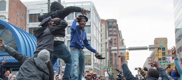 A demonstrator puts on a Baltimore City Police hat taken from a destroyed police car while protesting the death Freddie Gray, an African American man who died of spinal cord injuries in police custody, in Baltimore, Maryland, April 25, 2015 A demonstrator puts on a Baltimore City Police hat taken from a destroyed police car while protesting the death Freddie Gray, an African American man who died of spinal cord injuries in police custody, in Baltimore, Maryland, April 25, 2015 - Sputnik International