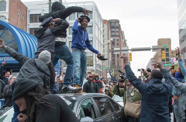 A demonstrator puts on a Baltimore City Police hat taken from a destroyed police car while protesting the death Freddie Gray, an African American man who died of spinal cord injuries in police custody, in Baltimore, Maryland, April 25, 2015 A demonstrator puts on a Baltimore City Police hat taken from a destroyed police car while protesting the death Freddie Gray, an African American man who died of spinal cord injuries in police custody, in Baltimore, Maryland, April 25, 2015 - Sputnik International