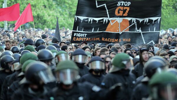 Protesters hold a banner reading ' Stop G7 - Fight Capitalism, Racism and War' as they take part in the 'Revolutionary' May Day demonstration in Berlin's Kreuzberg district on May 1, 2015 - Sputnik International