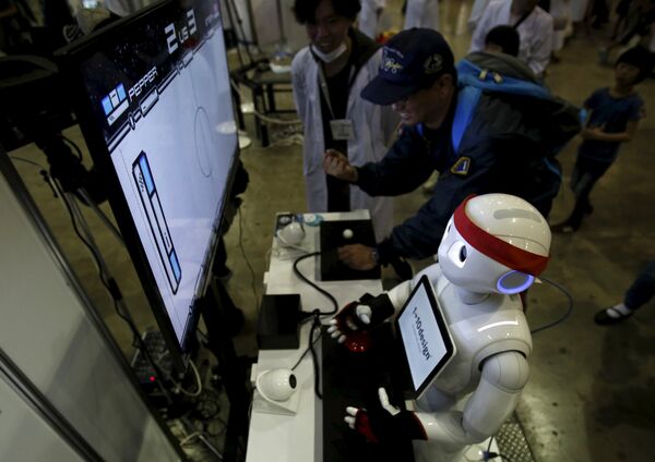 SoftBank Corp's humanoid robot named Pepper plays a video game against a visitor at a booth during Niconico Chokaigi 2015 in Makuhari, east of Tokyo, Japan April 26, 2015.  - Sputnik International