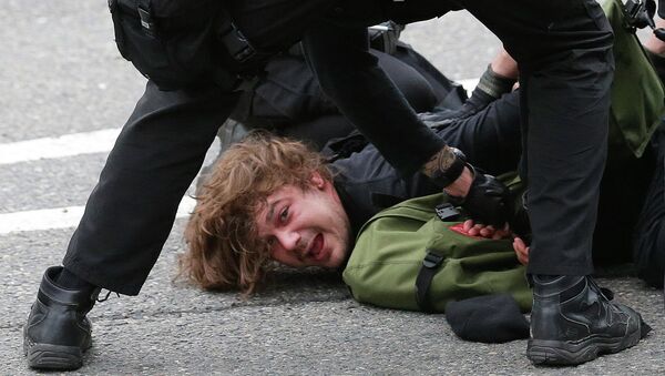 Police officers arrest a man during a May Day anti-capitalism march, Friday, May 1, 2015 in Seattle. - Sputnik International