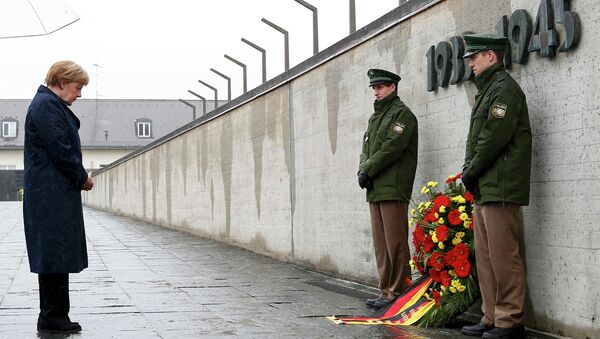 German Chancellor Angela Merkel observes a moment of silence as she lays a wreath during a ceremony at the memorial in the former German Nazi concentration camp in Dachau near Munich, Germany May 3, 2015 - Sputnik International