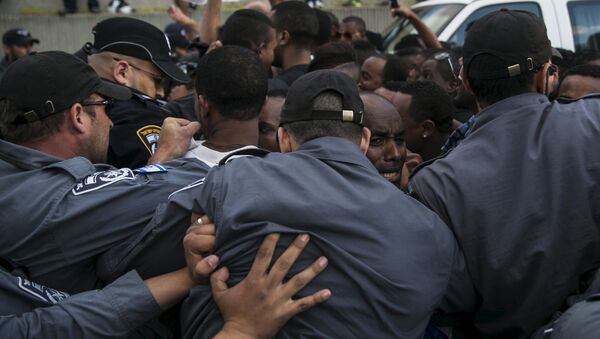 Israeli policemen push protesters, mainly whom are Israeli Jews of Ethiopian origin, during a demonstration against what they say is police racism and brutality, after the emergence last week of a video clip that showed policemen shoving and punching a black soldier during a protest in Tel Aviv May 3, 2015. - Sputnik International