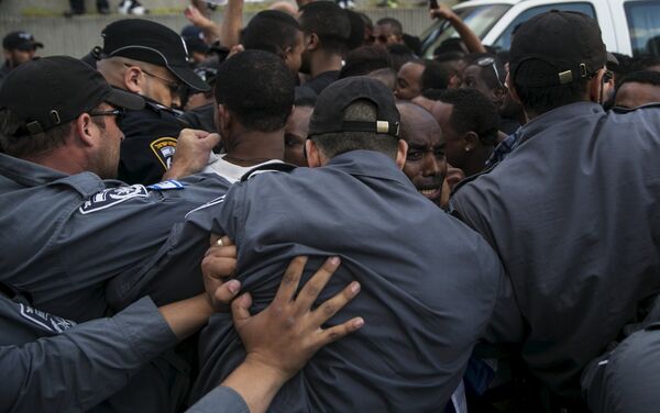 Israeli policemen push protesters, mainly whom are Israeli Jews of Ethiopian origin, during a demonstration against what they say is police racism and brutality, after the emergence last week of a video clip that showed policemen shoving and punching a black soldier during a protest in Tel Aviv May 3, 2015. - Sputnik International