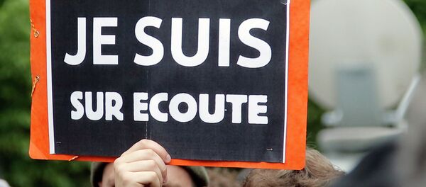 A demonstrator holds a placard that reads: I am on Record, during a gathering at Invalides, Paris, to protest against the emergency government surveillance law, Monday, May 4, 2015. A demonstrator holds a placard that reads: I am on Record, during a gathering at Invalides, Paris, to protest against the emergency government surveillance law, Monday, May 4, 2015. - Sputnik International
