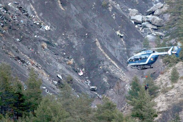 A rope hangs from a rescue helicopter flying past debris of the Germanwings passenger jet, scattered on the mountainside, near Seyne les Alpes, French Alps A rope hangs from a rescue helicopter flying past debris of the Germanwings passenger jet, scattered on the mountainside, near Seyne les Alpes, French Alps - Sputnik International