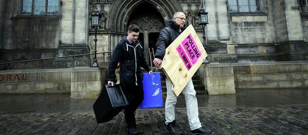 Polling Manager Scott Russel (R) and assistant Ross Clement deliver ballot boxes and a polling sign to a polling station on The Royal Mile in the centre of Edinburgh on May 6 2015 on the eve of the General election - Sputnik International