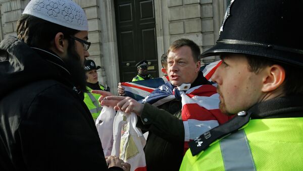 A Muslim demonstrator (L) speaks with an opposing nationalist demonstration group, as police stand by, near Downing Street in central London - Sputnik International