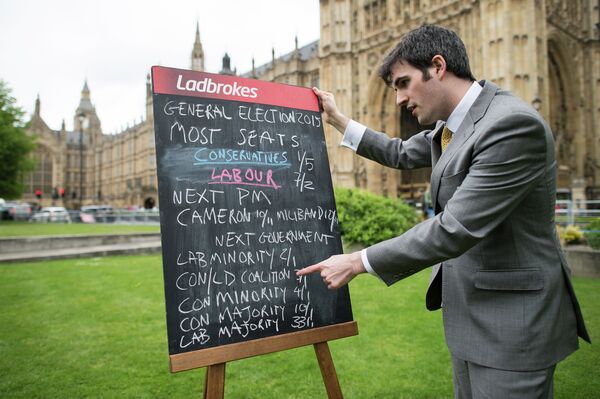 A bookmaker displays the latest odds on the result of the upcoming UK general election outside the Houses of Parliament in central London on May 6, 2015 A bookmaker displays the latest odds on the result of the upcoming UK general election outside the Houses of Parliament in central London on May 6, 2015 - Sputnik International