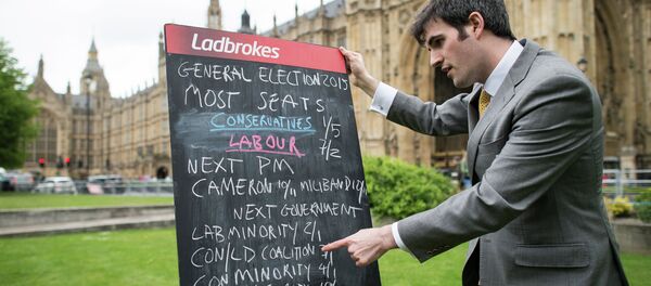 A bookmaker displays the latest odds on the result of the upcoming UK general election outside the Houses of Parliament in central London on May 6, 2015 - Sputnik International