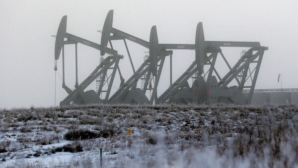 Oil pump jacks work in unison on a foggy morning in Williston, N.D - Sputnik International