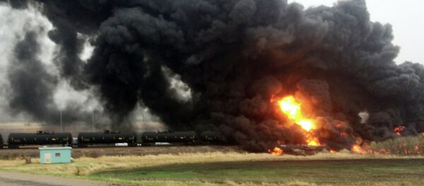 Smoke and fire rise from an oil train that derailed, Wednesday, May 6, 2015, in Heimdal, N.D. Smoke and fire rise from an oil train that derailed, Wednesday, May 6, 2015, in Heimdal, N.D. - Sputnik International