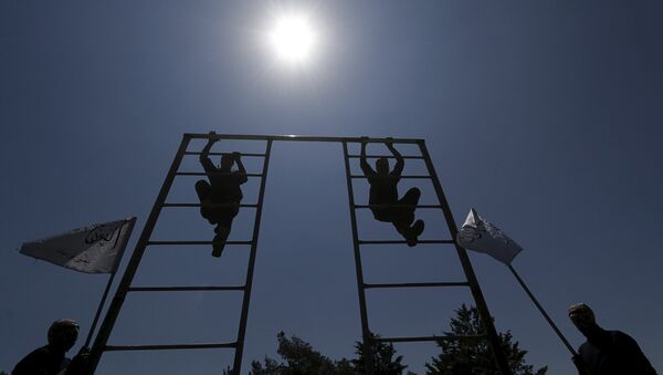 Rebel fighters from 'the First Regiment', part of the Free Syrian Army, climb on a bar as they participate in a military training in the western countryside of Aleppo May 4, 2015 - Sputnik International