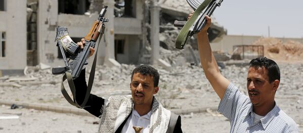 Houthi militants gesture in the yard of the residence of the military commander of the Houthi militant group, Abdullah Yahya al Hakim, after it was hit by an airstrike, in Sanaa April 28, 2015 - Sputnik International