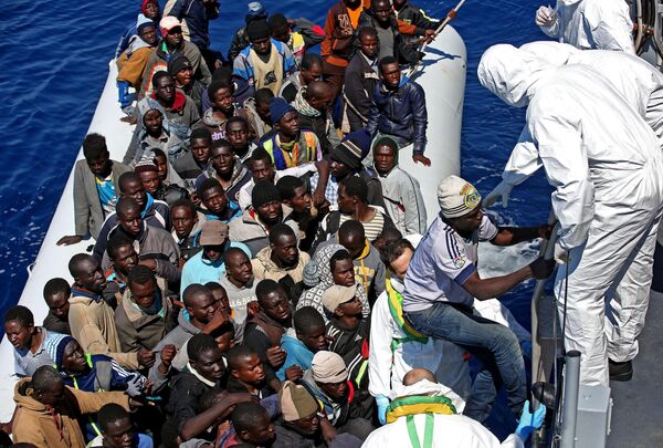 Migrants crowd and inflatable dinghy as rescue vassel Denaro of the Italian Coast Guard approaches them, off the Libyan coast, in the Mediterranean Sea, Wednesday, April 22, 2015 Migrants crowd and inflatable dinghy as rescue vassel Denaro of the Italian Coast Guard approaches them, off the Libyan coast, in the Mediterranean Sea, Wednesday, April 22, 2015 - Sputnik International
