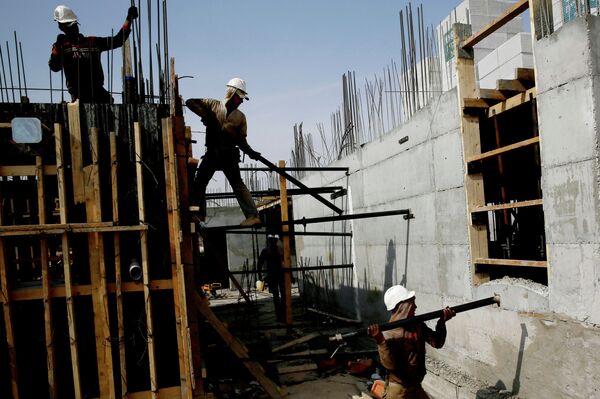 Palestinian laborers work on a construction site in Ramat Shlomo, a Jewish settlement in the mainly Palestinian eastern sector of Jerusalem, on October 30, 2013 Palestinian laborers work on a construction site in Ramat Shlomo, a Jewish settlement in the mainly Palestinian eastern sector of Jerusalem, on October 30, 2013 - Sputnik International