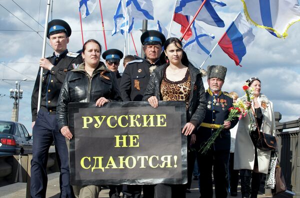 Russians pose as they celebrate Victory Day commemorating the end of WWII on May 9, 2009, at the WWII monument in Riga. Poster reads Russians will not give up. Russians pose as they celebrate Victory Day commemorating the end of WWII on May 9, 2009, at the WWII monument in Riga. Poster reads Russians will not give up. - Sputnik International