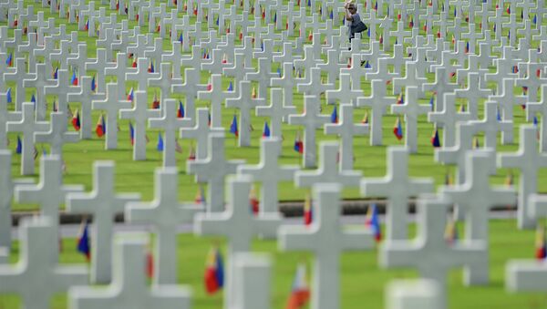 A woman walks amongst the graves of soldiers who fell during World War II, searching for a grave of a relative during a service to mark US Memorial Day at the Manila American Cemetery - Sputnik International