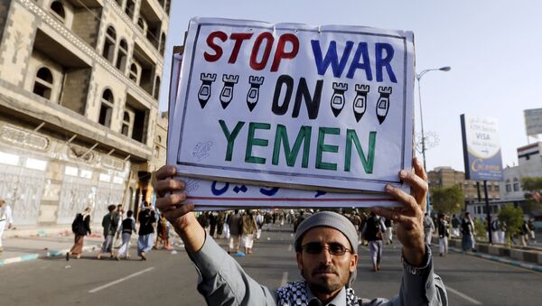 A follower of the Houthi group holds up a sign at the site of a demonstration against the air strikes by the Saudi-led coalition in Sanaa April 27, 2015 - Sputnik International