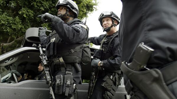 FBI agents in riot gear get information from a Los Angeles Police Department police officer (R) as they head towards the Mexican consulate in Los Angeles - Sputnik International