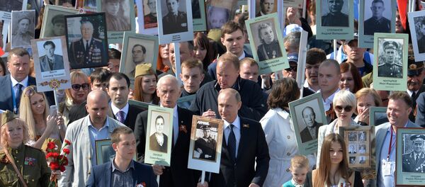 The president of the Russian Federation Vladimir Putin (in the center) during procession of Regional patriotic public organization Immortal Regiment Moscow along the Red Square - Sputnik International