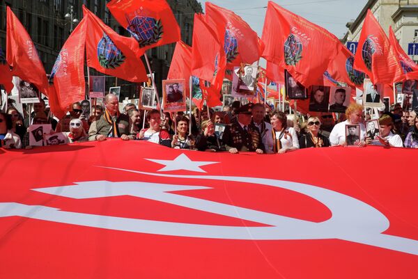 People hold a banner, a replica of the so-called Victory Standard which was erected at the top of the Reichstag building in Berlin at the end of World War Two, as they take part in the Immortal Regiment march during the Victory Day celebrations in central Moscow, Russia, May 9, 2015 - Sputnik International