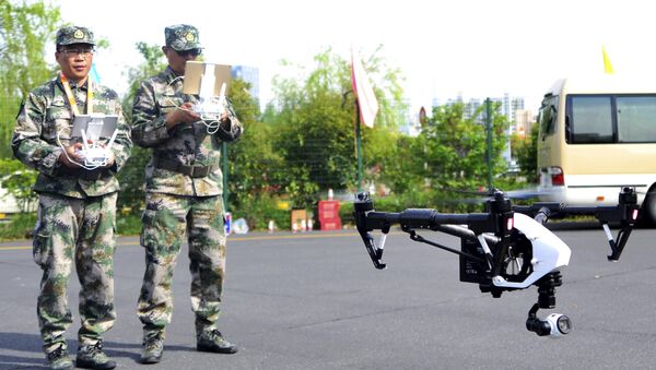 A pair of militia members fly drones during a test in Shanghai, China, April 21, 2015. - Sputnik International