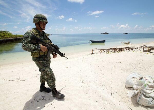 A Filipino soldier patrols the shore of disputed Pag-asa Island in the South China Sea. A Filipino soldier patrols the shore of disputed Pag-asa Island in the South China Sea. - Sputnik International