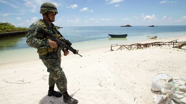 A Filipino soldier patrols the shore of disputed Pag-asa Island in the South China Sea. - Sputnik International