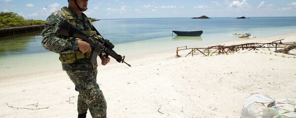 A Filipino soldier patrols the shore of disputed Pag-asa Island in the South China Sea. - Sputnik International