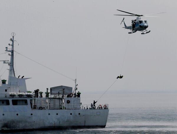 A wounded suspect is airlifted by a helicopter during a combined maritime exercise by Philippine and Japanese Coast Guards off Manila Bay. A wounded suspect is airlifted by a helicopter during a combined maritime exercise by Philippine and Japanese Coast Guards off Manila Bay. - Sputnik International